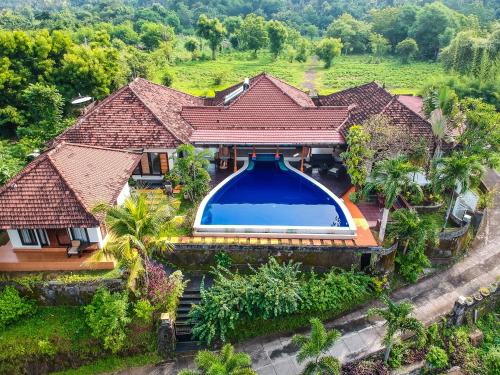 an aerial view of a house with a swimming pool at The Dharma Lovina - Mountain, Sea & Sunset View - Private Villa w Starlink - 5br in Lovina