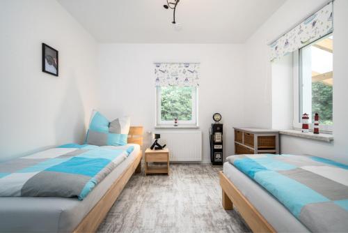 a bedroom with two beds and a window at FeWo Fischotter - EG 2 in Rechlin