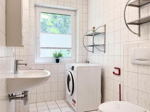 ボルテンハーゲンにあるUrlauberdorf Haus 20aの洗面台と洗濯機を備えた白いバスルーム