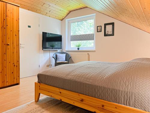 ボルテンハーゲンにあるUrlauberdorf Haus 20aのベッドと薄型テレビのある寝室