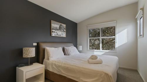 a bedroom with a bed and a window at Numbawan in Dinner Plain