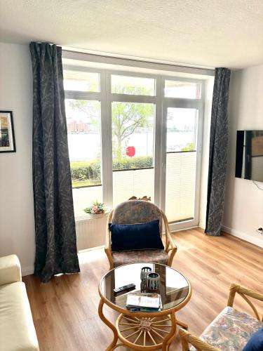 a living room with a coffee table and a window at Ferienwohnung Havenblick in Wilhelmshaven