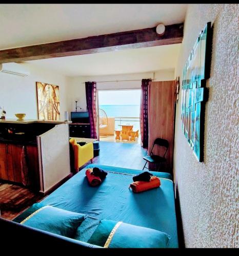 - une chambre avec un lit bleu et une vue sur l'océan dans l'établissement Studio vue sur Mer, à Conca