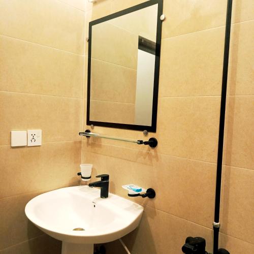a bathroom with a sink and a mirror at Riwayat Guest House in Islamabad