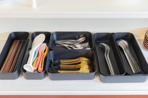 a drawer filled with plastic utensils on a shelf at nest Olive Atami in Atami