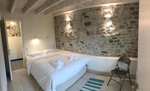 a bedroom with a bed and a stone wall at Footpath House / Ολόκληρο σπίτι στο Μεγάλο Χωριό in Méga Khoríon
