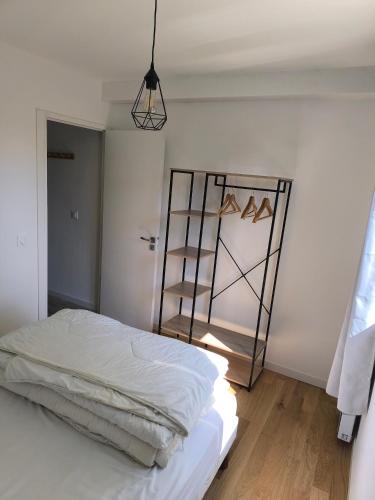 a bedroom with a bed and a book shelf at Plouharnel-Carnac-Quiberon bord de mer in Plouharnel