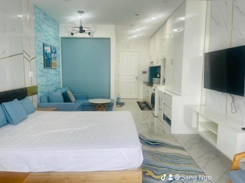 a bedroom with a large bed and a living room at Comfortable Family Apartment at Sealinks Mui Ne in Ấp Ngọc Hải