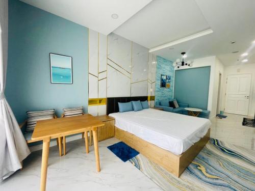 a bedroom with a bed and a wooden table at Comfortable Family Apartment at Sealinks Mui Ne in Ấp Ngọc Hải