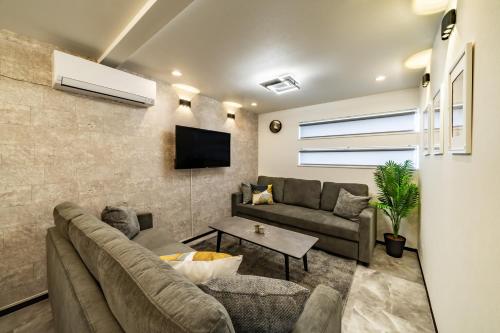 a living room with a couch and a tv at 91, Honancho A, Entire house for rent, 方南町A in Tokyo