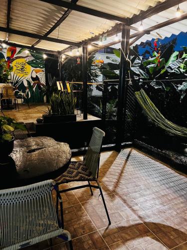 a patio with chairs and a mural of plants at CASA BLANCA Hostal in Minca