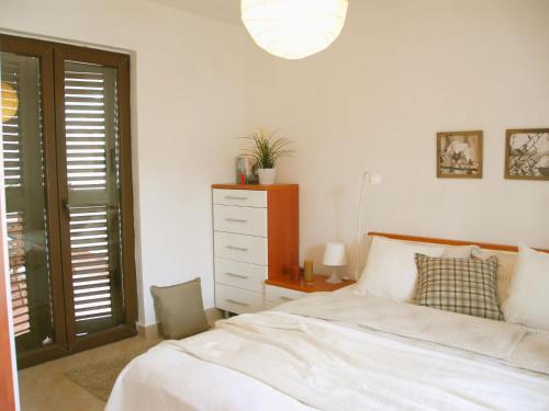 a bedroom with a bed and a dresser and a window at Holiday apartment Luna in Rogotin