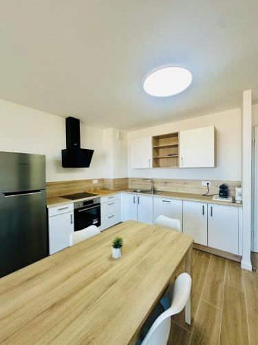 - une cuisine avec une table en bois et un réfrigérateur noir dans l'établissement Magnifique 2 pièces vue mer, à LʼÎle-Rousse