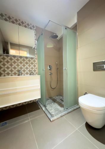 a bathroom with a glass shower and a toilet at Frezya - Exclusively Woman in Istanbul