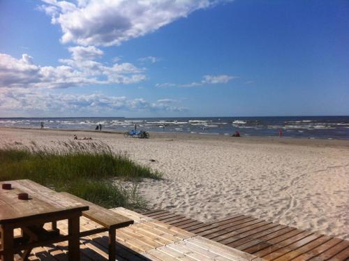 a beach with a wooden picnic table and the ocean at Beltes Street Family House in Jūrmala