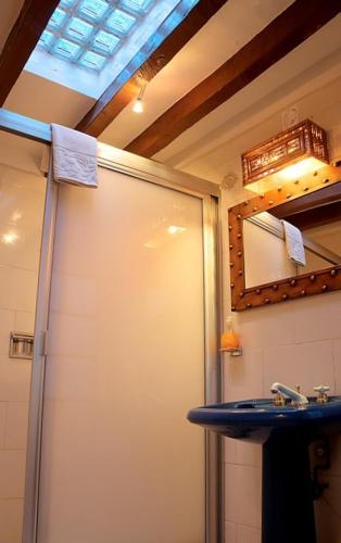 a bathroom with a shower and a sink and a mirror at El Zopilote Mojado in Guanajuato