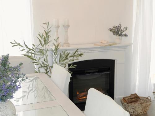 a fireplace in a living room with a white mantle at Apartments IVO in Stomorska