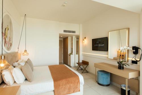 a hotel room with a bed and a desk at NissiBlu Beach Resort in Ayia Napa