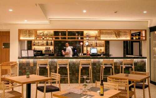 a man standing at the bar of a restaurant at Hotel Santanyi Port in Cala Figuera