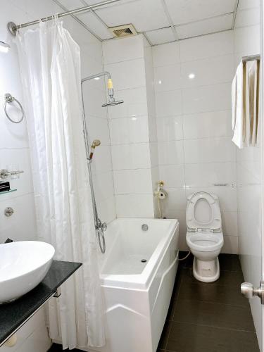 a white bathroom with a toilet and a sink at Khách sạn Nam Môn in Can Tho