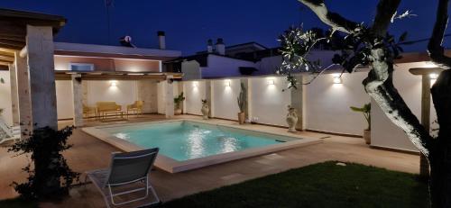 a swimming pool in the backyard of a house at night at Casa Valerio in Conversano