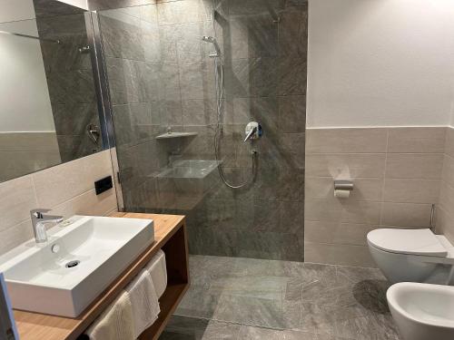 a bathroom with a shower and a sink and a toilet at Residence Terentis in Terento