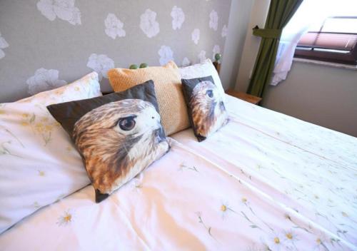 a bed with two owl pillows on it at Gościniec Malinówka in Krzeszna