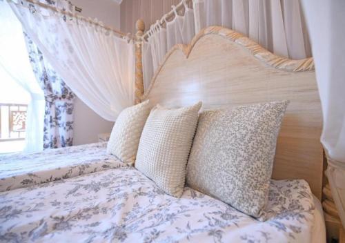 a bedroom with a bed with a canopy and pillows at Gościniec Malinówka in Krzeszna
