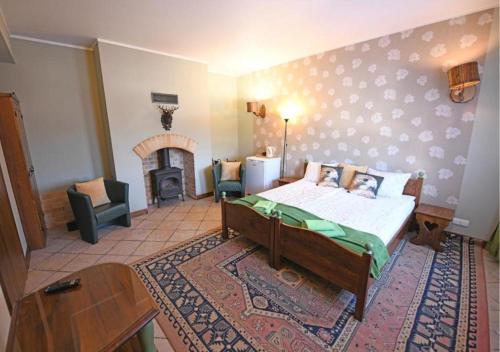 a bedroom with a bed and a fireplace at Gościniec Malinówka in Krzeszna