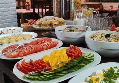 a table full of plates of food with vegetables at Gościniec Malinówka in Krzeszna