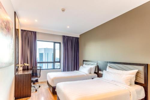 a hotel room with two beds and a window at Shama Suasana Johor Bahru Formerly known as Suasana All Suites Hotels Johor Bahru in Johor Bahru