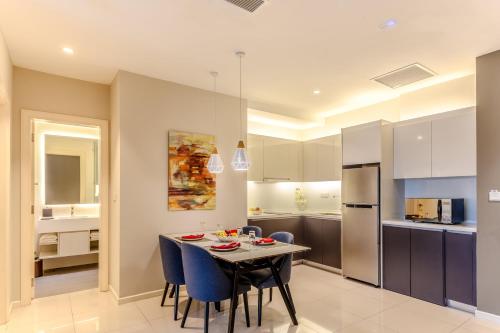 a kitchen and dining room with a table and chairs at Shama Suasana Johor Bahru Formerly known as Suasana All Suites Hotels Johor Bahru in Johor Bahru