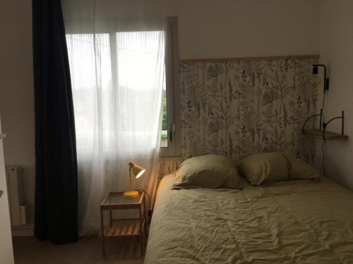 une chambre avec un grand lit avec une fenêtre dans l'établissement Appartement coup de cœur, à Saint-Michel-Chef-Chef