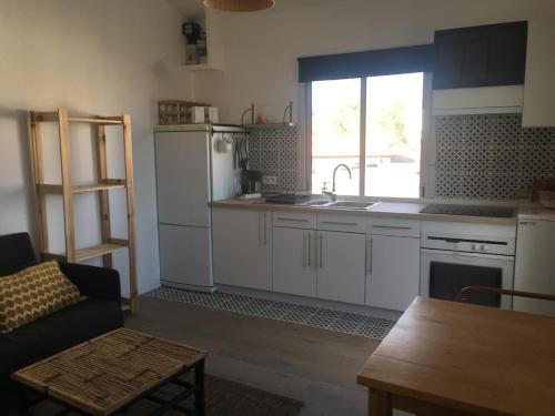 une cuisine avec des placards blancs et une grande fenêtre dans l'établissement Appartement coup de cœur, à Saint-Michel-Chef-Chef