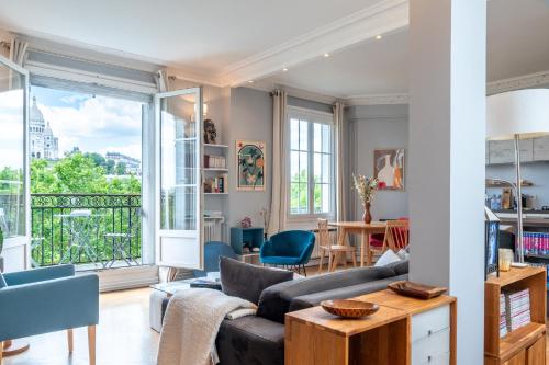 un salon avec un canapé et une table dans l'établissement Montmartre - Appartement avec vue sur le Sacré-Cœur, à Paris