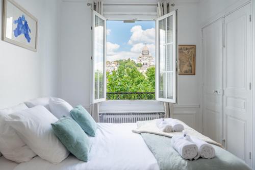 - une chambre avec un lit et une vue sur la ville dans l'établissement Montmartre - Appartement avec vue sur le Sacré-Cœur, à Paris