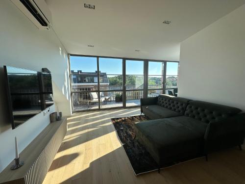 a living room with a couch and a large window at V7 Apartamentai Nidoje in Nida