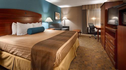 a hotel room with a large bed and a desk at Days Inn by Wyndham Englewood Dayton Airport in Dayton