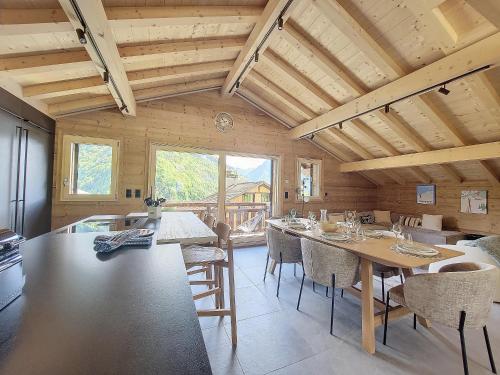 une cuisine avec une table et des chaises dans une pièce dans l'établissement Chalet SKADI, à Essert-Romand