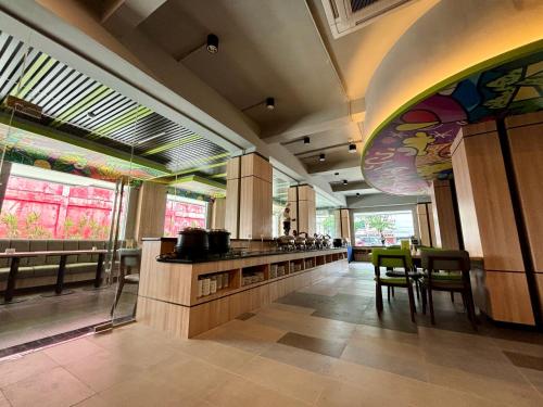 a kitchen with a counter and some chairs and windows at MAXONE Dumai in Dumai