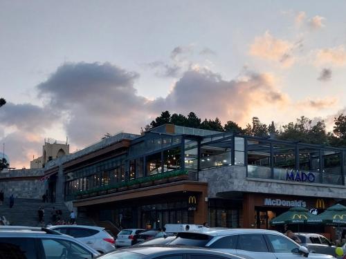 a building with cars parked in a parking lot at Banu House in Sumqayyt