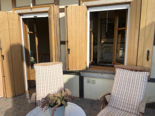 a porch with two chairs and a table and windows at Wake-up-by-the-sea! in Nydri