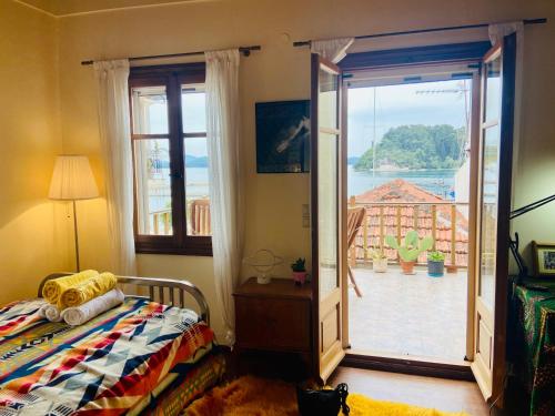a bedroom with a bed and a door to a balcony at Wake-up-by-the-sea! in Nydri