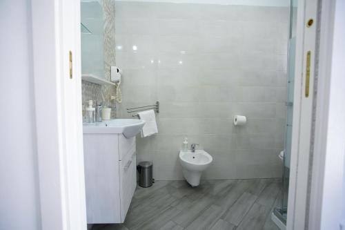 a white bathroom with a sink and a toilet at Casa Fiorita in Gragnano