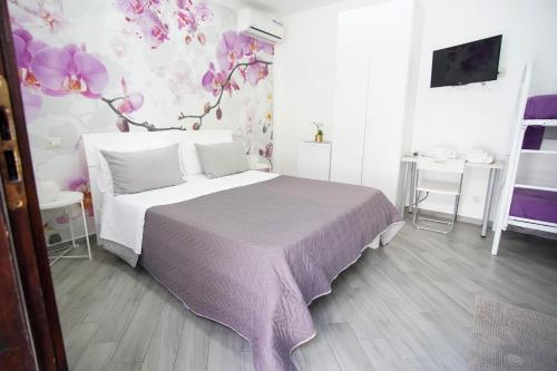 a bedroom with a bed with a purple blanket at Casa Fiorita in Gragnano