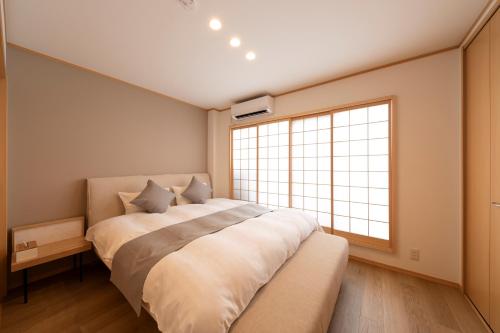 a bedroom with a large bed and a large window at Shirakabanoyado - HATSUMI, 白樺の宿 - 初美 in Osaka