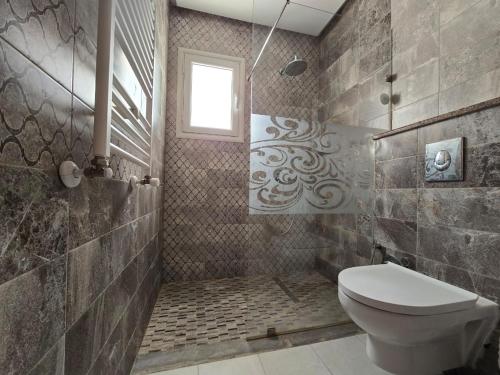 une salle de bain avec toilettes et fenêtre dans l'établissement Villa Elaa, à Temlale