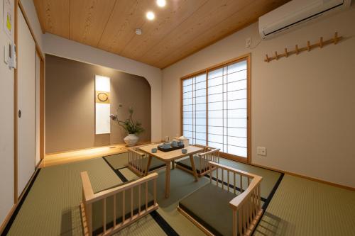 a room with a table and chairs and a window at Shirakabanoyado - HATSUMI, 白樺の宿 - 初美 in Osaka