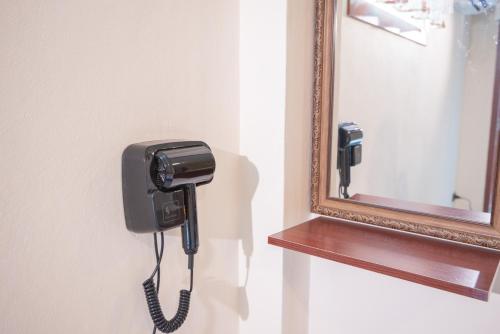 a phone on a wall next to a mirror at JB Home Bangkok - Victory monument in Bangkok