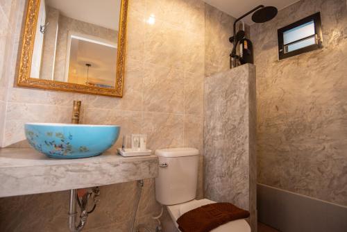 a bathroom with a sink and a toilet and a mirror at JB Home Bangkok - Victory monument in Bangkok